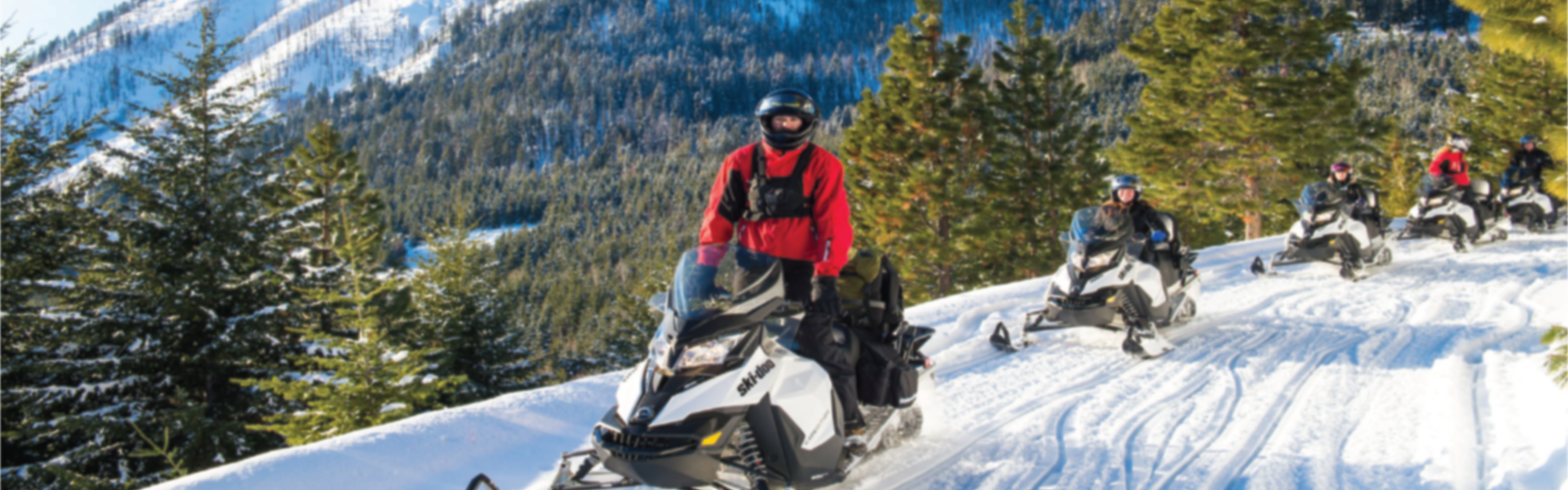 Snow mobiles traveling on mountain side